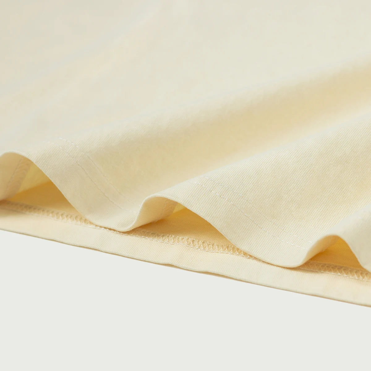 Ivory Everyday Tee fabric and double rows of stitching along its hem.